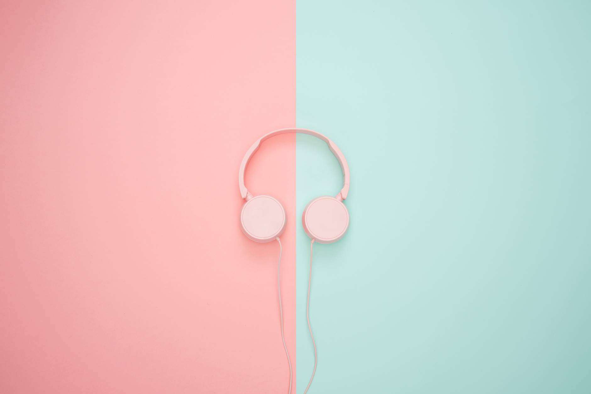 pink corded headphones on pink and teal wall