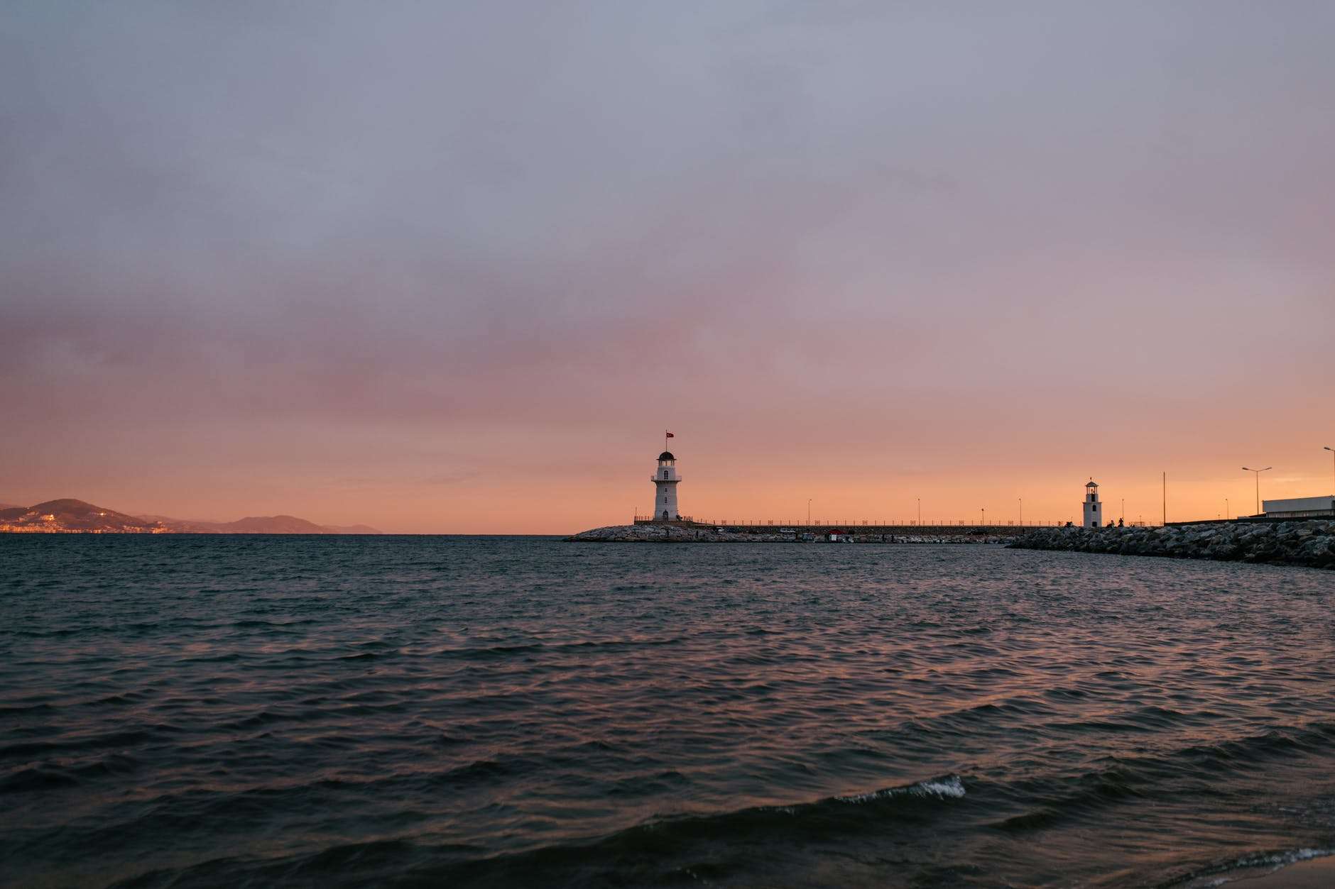 peaceful evening seashore with remote lighthouse
