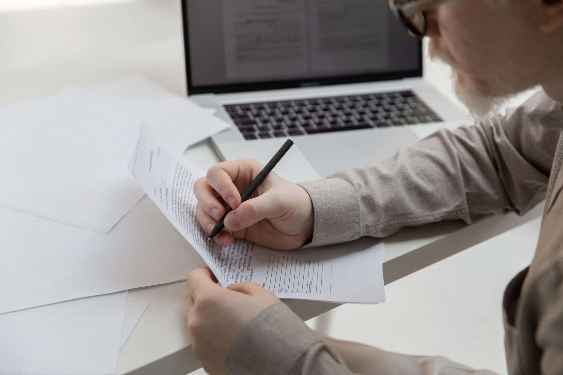 crop office employee working with document near laptop